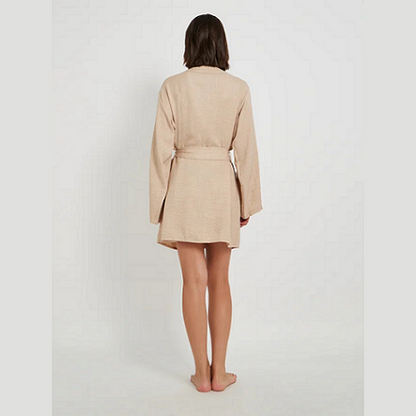 Woman wearing a beige robe on a white background